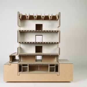 A photo of a section model showing 5 floors, including the basement and load-bearing structure. MDF, gray cardboard.