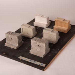 A painted wooden board featuring 6 models made from different materials: plaster, wood, concrete.