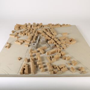 An urban planning model of a dense city area with an inserted design. MDF, gray cardboard.