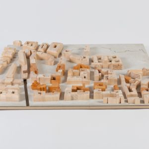 A model photo of an urban planning model of a dense urban area. MDF, grayboard, wood.